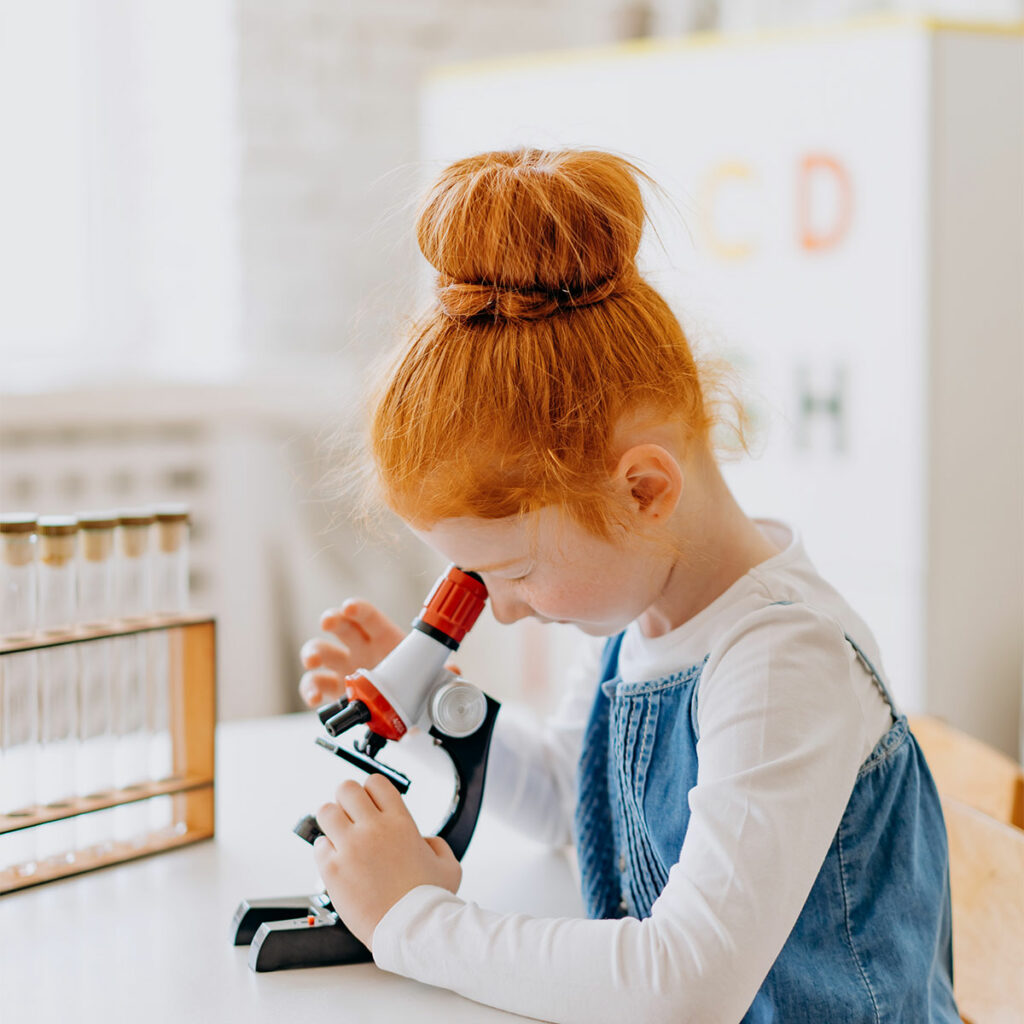 Kind kijkt door een microscoop